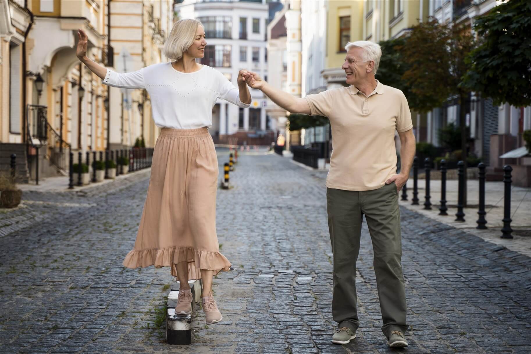 Photo of a senior couple dancing on the street.